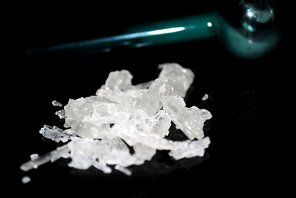 photo of meth crystals next to a glass pipe